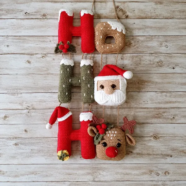 Guirlanda Ho Ho Ho em crochê com letras vermelhas, verdes e detalhes de Papai Noel e rena